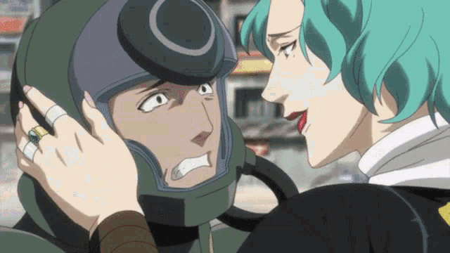 a woman with green hair is touching a man 's ear