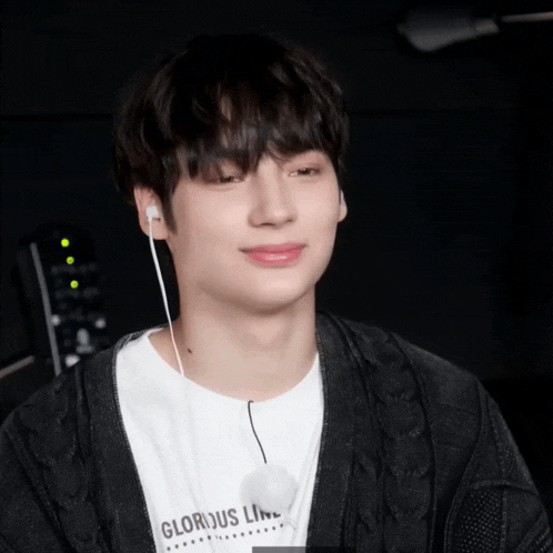 a boy wearing ear buds and a shirt that says glorious line