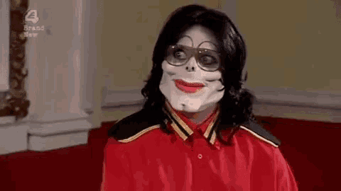 a man wearing a red shirt and a skeleton mask is smiling .