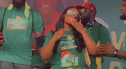 a woman in a green t-shirt is standing in front of a group of people .