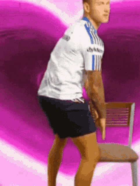 a man is squatting on a chair in front of a purple heart .
