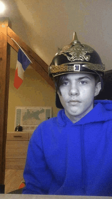 a young man wearing a blue hoodie and a helmet