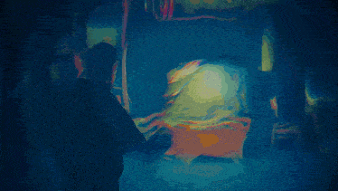 a man is standing in front of a television with a glowing light on it