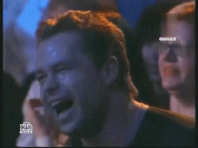 a man is crying in front of a tv screen that says ntv
