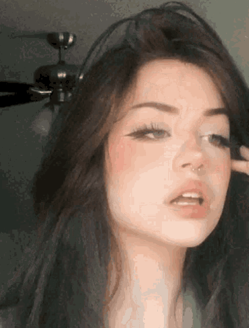 a close up of a girl 's face with a nose ring .