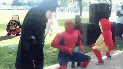 a group of people dressed as spiderman and iron man are dancing in a park