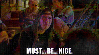 two women are standing next to each other on a street and one of them is saying `` must ... be ... nice '' .