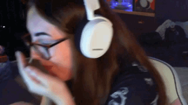 a woman wearing glasses and white headphones looks at something