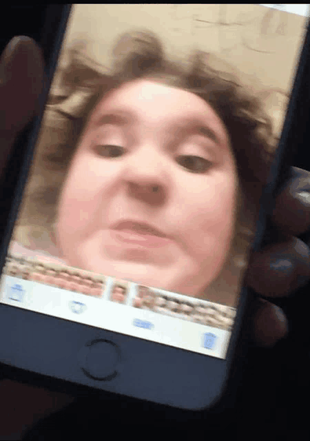 a person is holding a phone with a picture of a girl on it