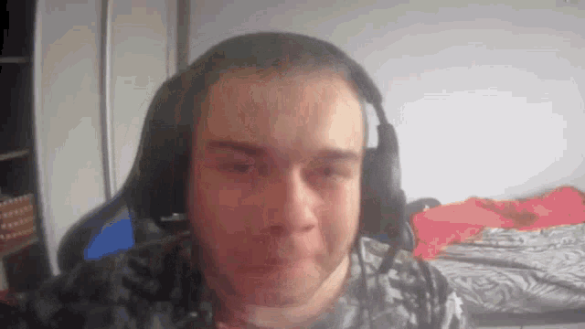 a man wearing headphones is making a funny face while looking at the camera .