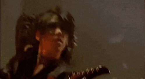 a close up of a person holding a microphone in a dark room with their hand in the air .