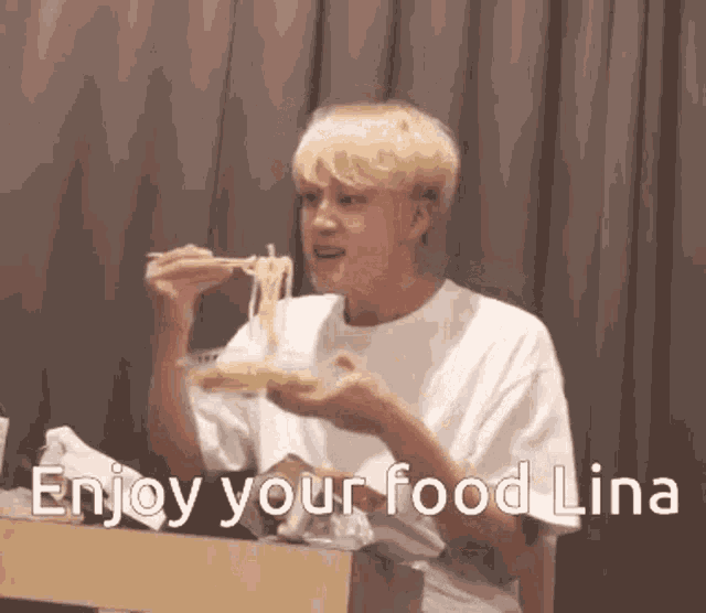 a man is sitting at a table eating noodles with chopsticks and the words `` enjoy your food lina '' .