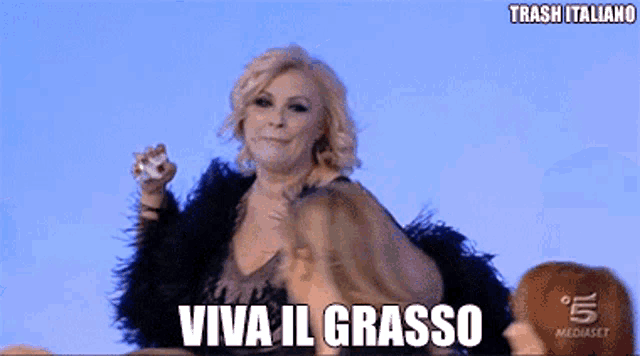 a woman in a fur coat says viva il grasso on a blue background