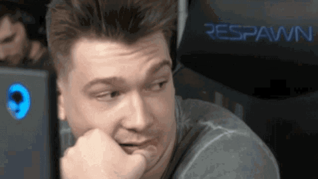 a man is sitting in a respawn chair looking at a computer screen .