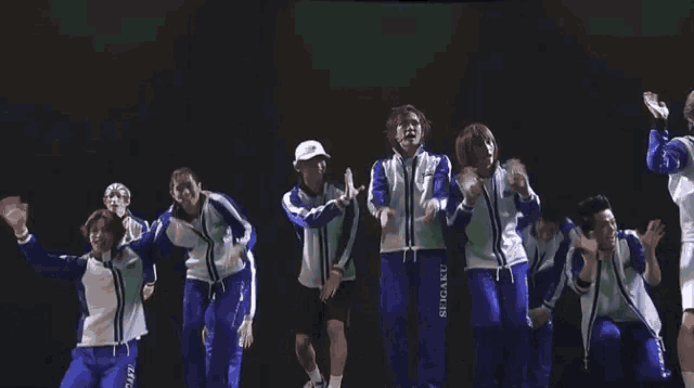 a group of people wearing blue uniforms with the letter a on the front