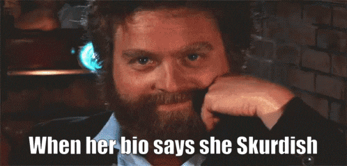 a man with a beard is smiling with the words when her bio says she skurdish below him