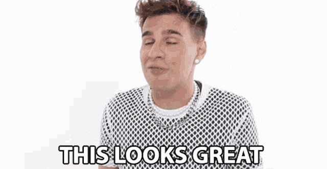 a young man is making a funny face and saying `` this looks great '' while wearing a black and white sweater .