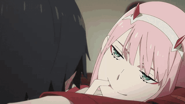 a girl with pink hair is laying on a man 's shoulder