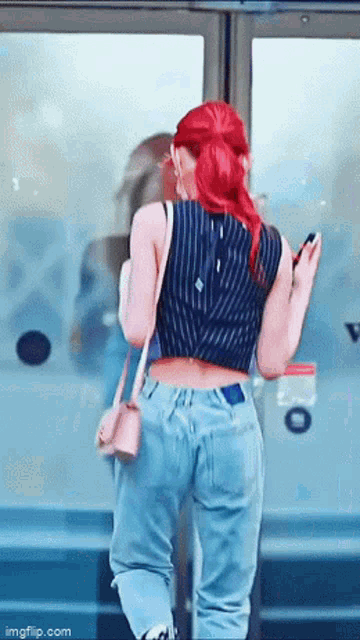 a woman with red hair is standing in front of a glass door