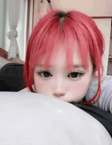 a girl with red hair and black eyes looks over a white blanket