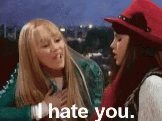 two girls are standing next to each other and one of them says i hate you