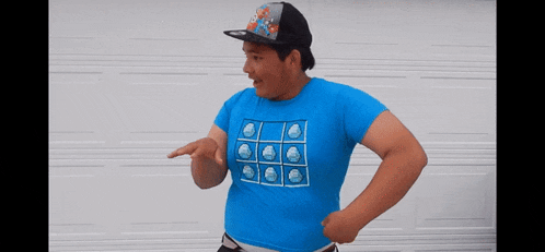 a man wearing a blue shirt and a hat is pointing at something
