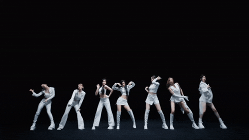 a group of women in white clothes are dancing together
