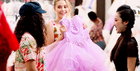 a woman in a purple dress is holding a purple dress .