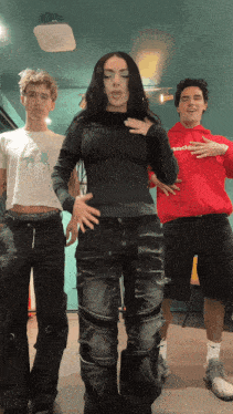 a man in a red hoodie is standing next to two other men