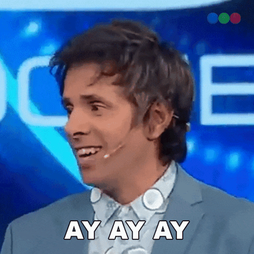 a man wearing a suit and a microphone is smiling and saying ay ay ay