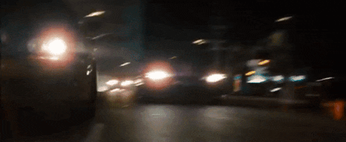 a blurry picture of a car driving down a road at night