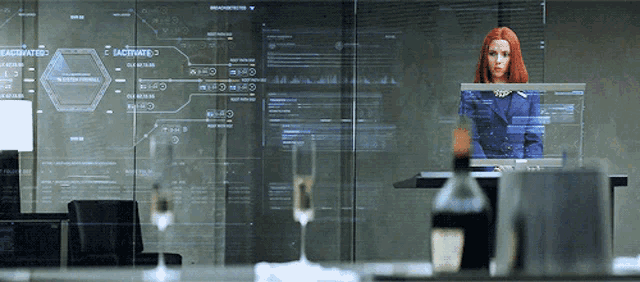 a woman stands in front of a computer screen that says " activated " on it