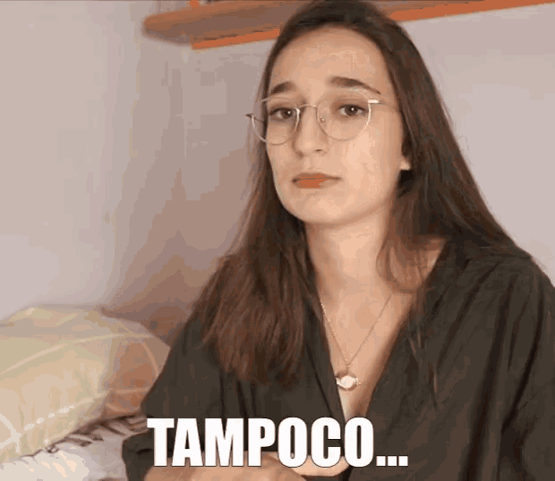 a woman wearing glasses and a necklace has the word tampoco written on her face