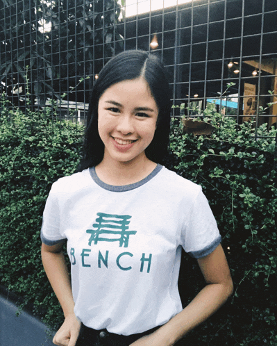 a woman wearing a white shirt that says bench