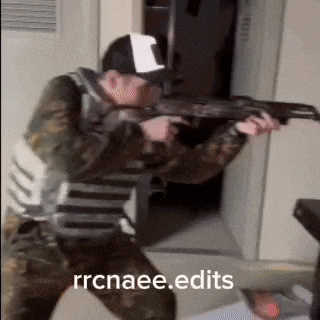 a man in a military uniform is holding a gun in a room and says rrcnaee.edits .