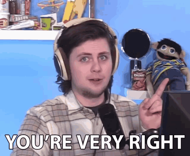 a man wearing headphones says " you 're very right " in front of a microphone