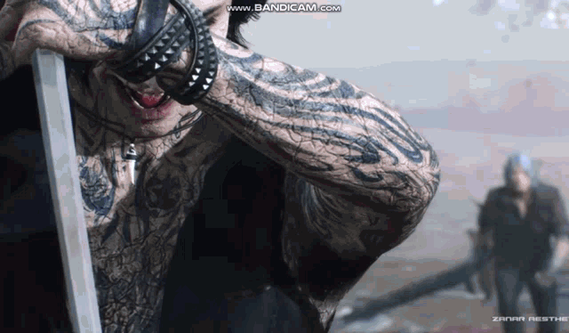 a man with a lot of tattoos holds a sword
