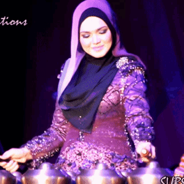 a woman in a purple dress is playing a musical instrument with the word actions in the background