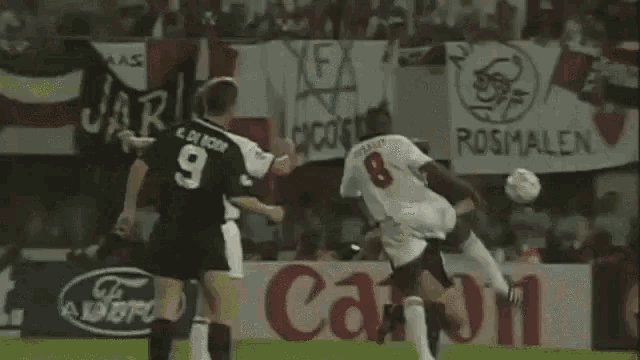 a soccer player wearing a number 8 jersey is jumping in the air