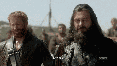 two bearded men are standing next to each other and one of them is saying " jesus "