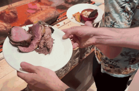 a man in a hawaiian shirt holds a plate of food