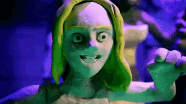 a statue of a woman with green hair and big eyes is smiling
