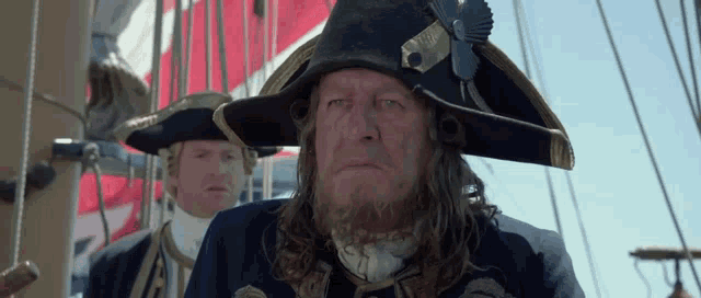 a man with long hair and a beard wearing a hat that says ' captain ' on it