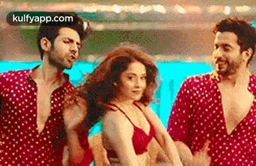 a group of men and a woman are dancing in a pool .