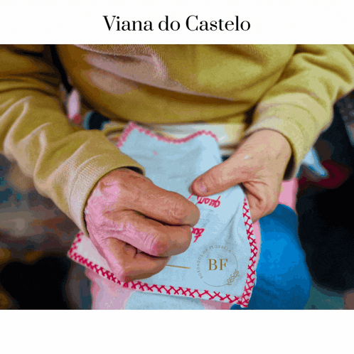 a person is holding a piece of cloth with the words viana do castelo written above them