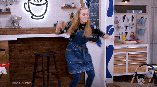 a woman is dancing in front of a coffee cup sign