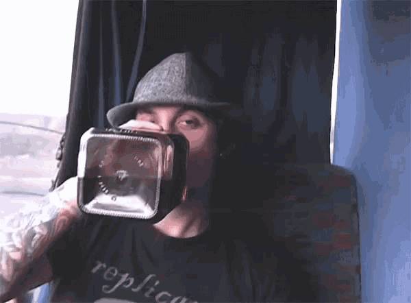 a man wearing a replica shirt drinking from a bottle