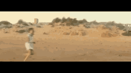 a person is running through a desert with a jeep in the background .