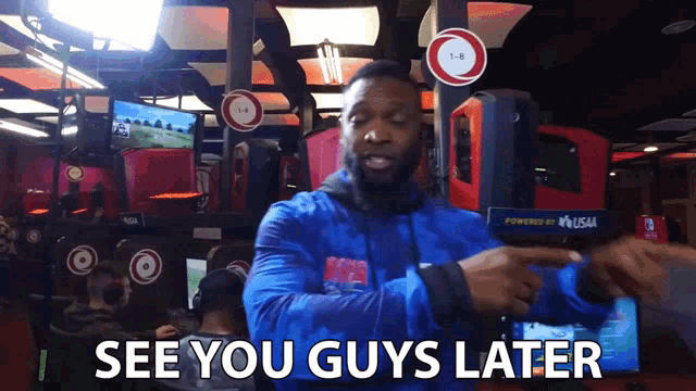 a man in a blue jacket says " i see you guys later " in a video game room