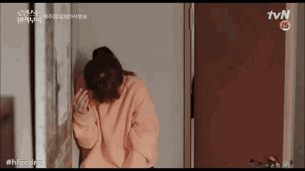 a woman in a pink sweater is sitting in front of a tvn logo